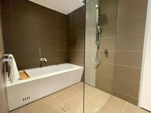 a bathroom with a bath tub and a shower at Sydney City Side Beauty @ Chippendale 1 Bedroom Aircon in Sydney