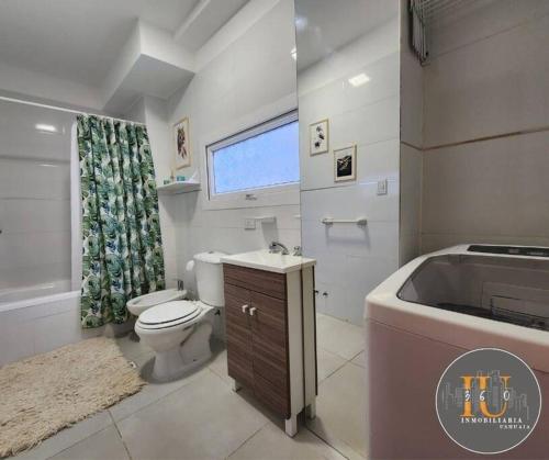 a bathroom with a toilet and a sink and a tub at Aima II in Ushuaia