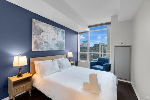 a bedroom with a large bed and a blue wall at Spacious 2BR - Pool Gym Sauna Hot Tub Free Parking in Toronto