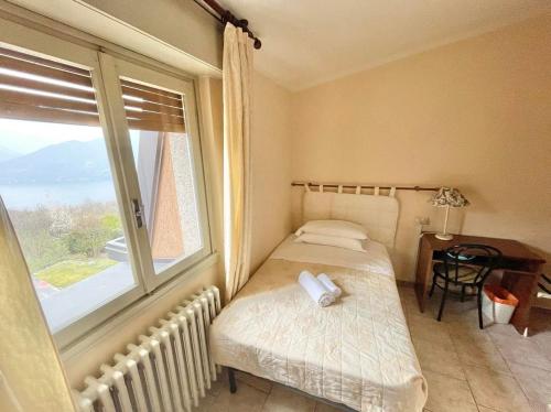a small bedroom with a bed and a window at Hotel Ristorante La Sorgente in Plesio