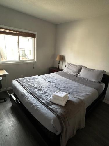 a bedroom with a large bed with two towels on it at Comfortable room C in Kitchener
