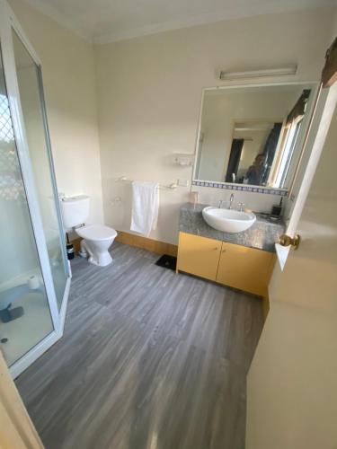 a bathroom with a toilet and a sink and a mirror at Master Ensuite and private balcony in White Rock