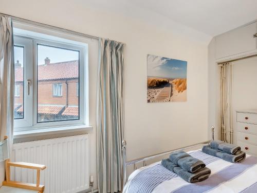 1 dormitorio con cama y ventana en Manderley, en Sheringham