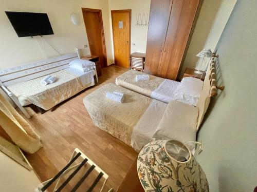 una camera con due letti e una sedia di Hotel Ristorante La Sorgente a Plesio