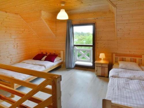 Storey holiday cottages, Siano ty في سيانوزيتي: غرفة نوم بسريرين في كابينة خشبية