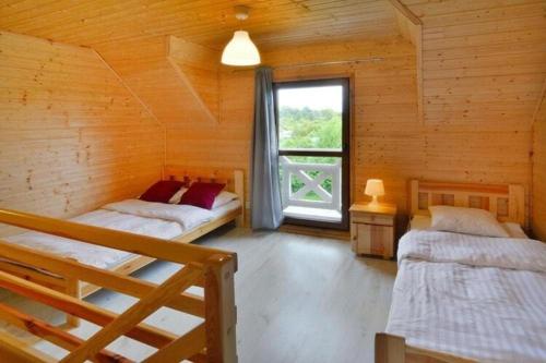 a bedroom with two beds in a log cabin at Comfortable holiday cottages, Siano ty in Sianozety