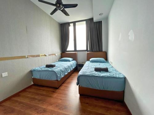 two beds in a room with a ceiling fan at DS VivacityMall Jazz Suite 3 810 in Kuching