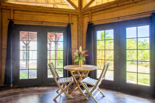 a table with chairs and a vase of flowers on it at Kalani Oceanside Retreat in Pahoa