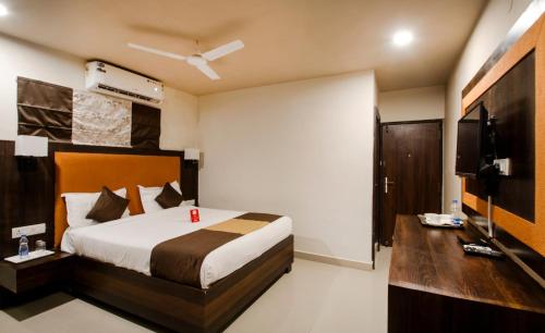 a bedroom with a bed and a flat screen tv at Collection O Hotel Park Heights Banjara Hills Near Gvk One Mall in Hyderabad