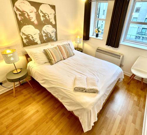 um quarto com uma cama branca e um cartaz na parede em Fernandos Flats! Stunning Soho Apartments, meters from Piccadilly Circus, 2 Beds em Londres