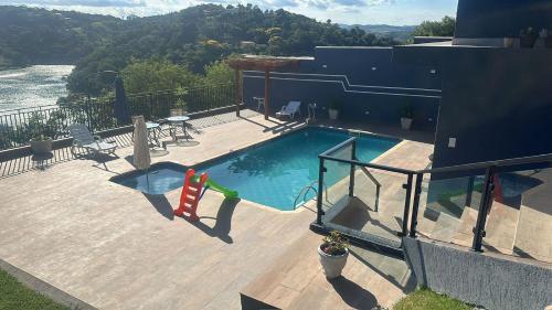 una piscina en la parte superior de una casa en Chácara Gama em condomínio Igarata-SP - Jacuzzi com hidromassagem, piscina e sauna en Igaratá