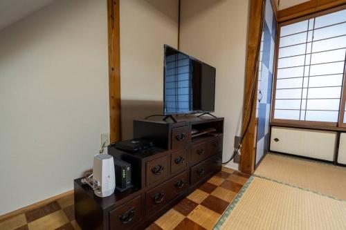 a living room with a tv on top of a dresser at Seaside House Nagi in Itoigawa