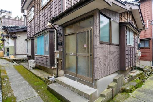 a building with a door on the side of it at Seaside House Nagi in Itoigawa