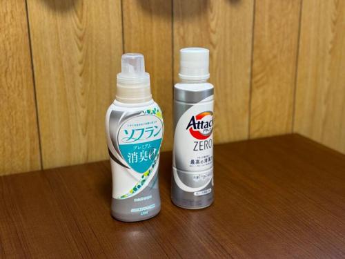 two bottles of hair products sitting on a wooden table at Seaside House Nagi in Itoigawa