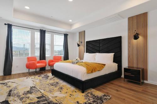 um quarto com uma cama grande e 2 cadeiras laranja em Canneto Way - Large villa w/ a large backyard em Indio