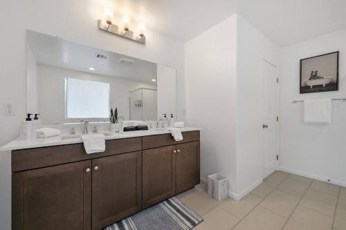 a bathroom with a sink and a large mirror at Canneto Way - Large villa w/ a large backyard in Indio