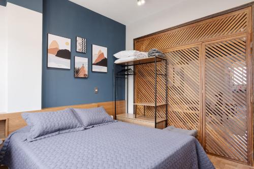 a bedroom with a bed and a blue wall at Studio na quadra da praia de Copacabana in Rio de Janeiro