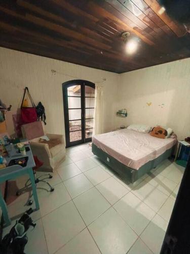 um quarto com uma cama, uma secretária e uma cadeira em Lar Pôr-do-Sol do Sambaqui em Florianópolis