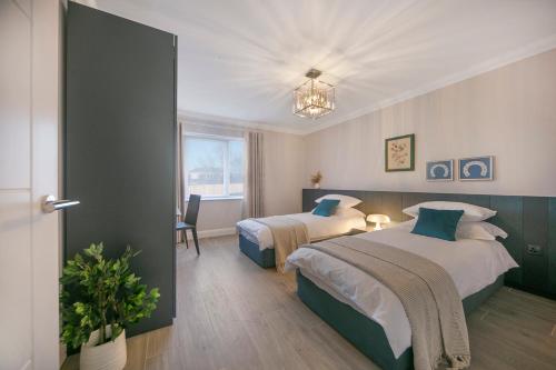 een hotelkamer met 2 bedden en een raam bij Luxury Hazledene Villa #14 - Grampian Lettings Ltd in Aberdeen