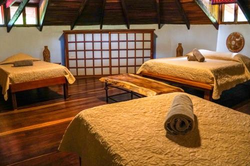 a room with three beds at Hotel Boruca Tamarindo in Tamarindo