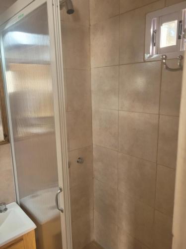 een douche met een glazen deur in de badkamer bij Departamento céntrico in Tres Arroyos