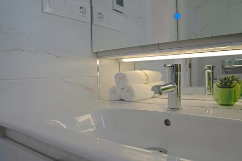 uma casa de banho com lavatório e toalhas num balcão em Penthouse , Sea View @ Roof Top , 4 Min to Beach em Santa Pola