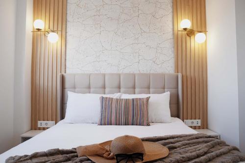 um chapéu sentado numa cama com cabeceira em Penthouse , Sea View @ Roof Top , 4 Min to Beach em Santa Pola