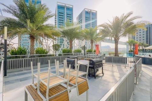 a balcony with tables and chairs and palm trees at Cozy studio, amazing amenities in Dubai