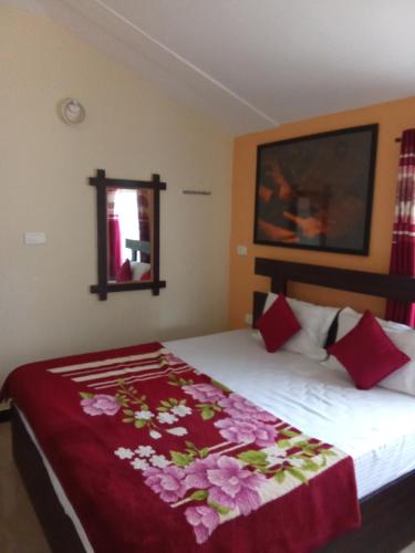 1 dormitorio con 1 cama con manta roja en Queenhill Homestay Ooty en Ooty