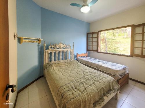 Schlafzimmer mit einem Bett und einem Fenster in der Unterkunft Nosso Apê Enseada: Casa na Represa João Penido com Wifi, Piscina e Churrasqueira in Juiz de Fora