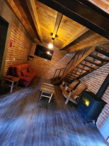 Cette chambre mansardée dispose d'un canapé et d'un poêle à bois. dans l'établissement Cabaña Sasquatch, à Tapalpa