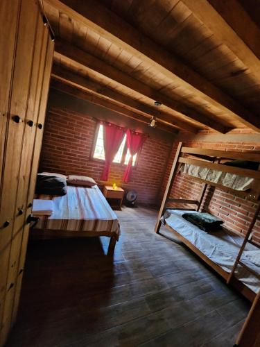 Cette chambre comprend 2 lits superposés et une fenêtre. dans l'établissement Cabaña Sasquatch, à Tapalpa