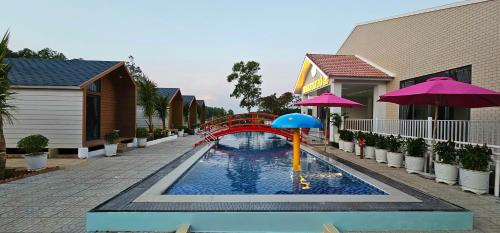 a small pool with a red bridge and an umbrella at Khách sạn Lake Side Palace - Bờ Hồ in Phuoc Buu