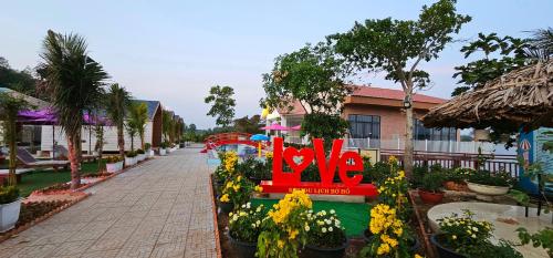 a red bench in the middle of a street with flowers at Khách sạn Lake Side Palace - Bờ Hồ in Phuoc Buu