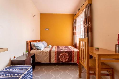 - une chambre avec un lit, une table et un bureau dans l'établissement Homely Queen Bed Apartment Near Nairobi CBD, à Nairobi