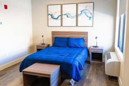 1 dormitorio con 1 cama azul y 2 mesitas de noche en Modern and Convenient Norwood Knox en Knoxville