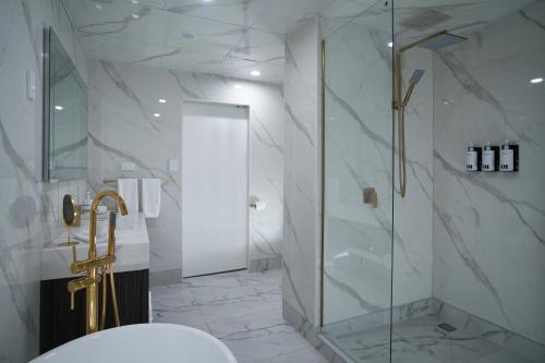 SOHO Hotel Auckland في أوكلاند: حمام مع دش ومرحاض ومغسلة
