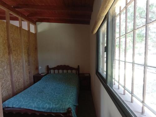1 dormitorio con 1 cama junto a una ventana en Liland en Capilla del Señor
