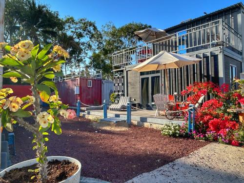 un patio con mesa, sombrilla y flores en Casa Garfio, en Barra de Navidad