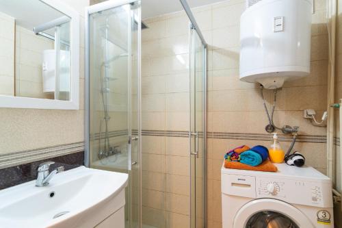 een badkamer met een wasmachine en een wastafel bij • Skopje Downtown ǀ 2 Bedrooms ǀ Parking • in Skopje