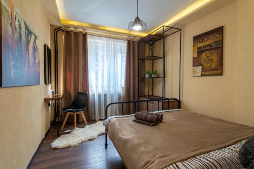 een slaapkamer met een bed, een stoel en een raam bij • Skopje Downtown ǀ 2 Bedrooms ǀ Parking • in Skopje