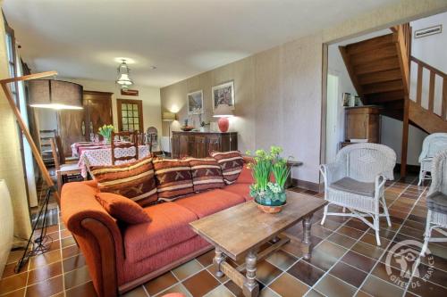 un salon avec un canapé et une table dans l'établissement Du corps de garde, à Lancieux