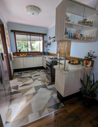 a kitchen with a tile floor with a stove top oven at The Oars Retro B&B in Warnbro