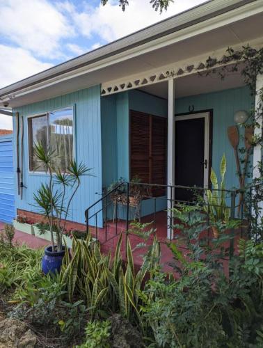 a blue house with plants in front of it at The Oars Retro B&B in Warnbro