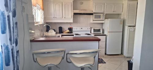 a kitchen with white appliances and white cabinets at Seaview property Hastings Towers 3D-Studio Apt in Bridgetown