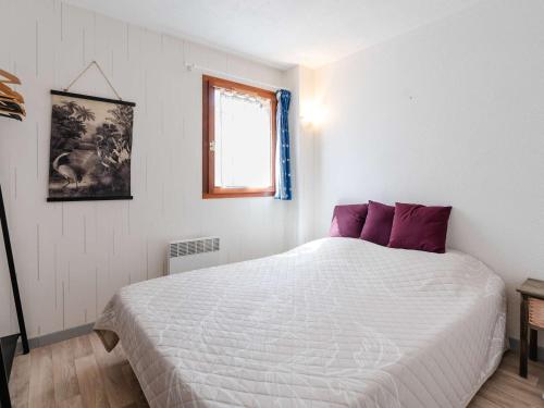 une chambre avec un grand lit blanc avec des oreillers violets dans l'établissement Pavillon 3 pièces proche plage avec terrasse et parking privé - FR-1-409-185, à Narbonne