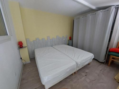 - une petite chambre avec un lit blanc dans l'établissement Pavillon climatisé 4/5 pers, grande terrasse, proche plage et commerces, parking sécurisé - FR-1-776-6, à Argelès-sur-Mer