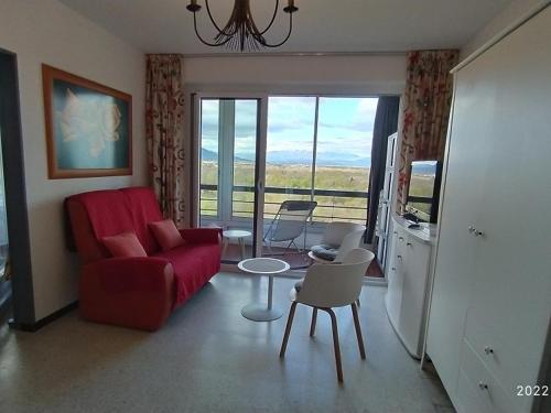 - un salon avec un canapé rouge, une table et des chaises dans l'établissement Studio 4 pers avec terrasse, parking et WIFI à 500m de la plage - FR-1-776-39, à Argelès-sur-Mer