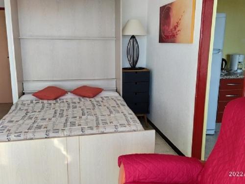 une chambre avec un lit et une chaise rouge dans l'établissement Studio 4 pers avec terrasse, parking et WIFI à 500m de la plage - FR-1-776-39, à Argelès-sur-Mer