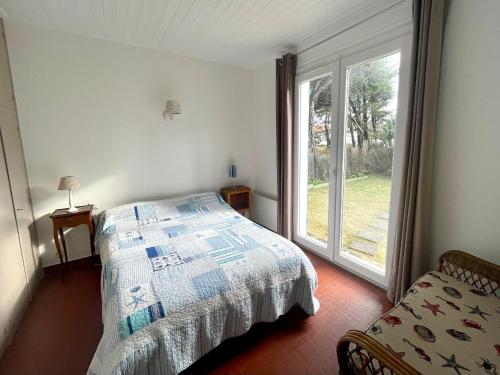 une chambre avec un lit et une grande fenêtre dans l'établissement Maison familiale 3 chambres avec jardin, terrasse en bois, proche de la mer et des sentiers. - FR-1-231-313, à Bretignolles-sur-Mer